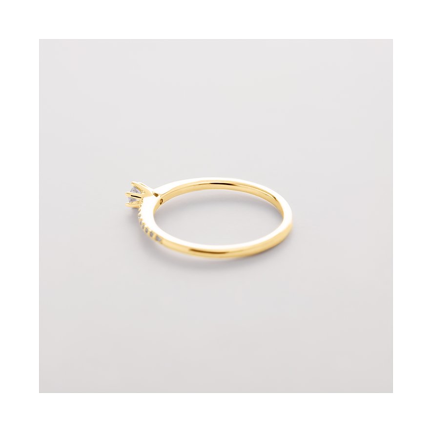 CHRIST Gelbgoldring mit einem einzelnen Diamanten und kleinen Diamanten auf der Ringschiene, von oben rechts gesehen.