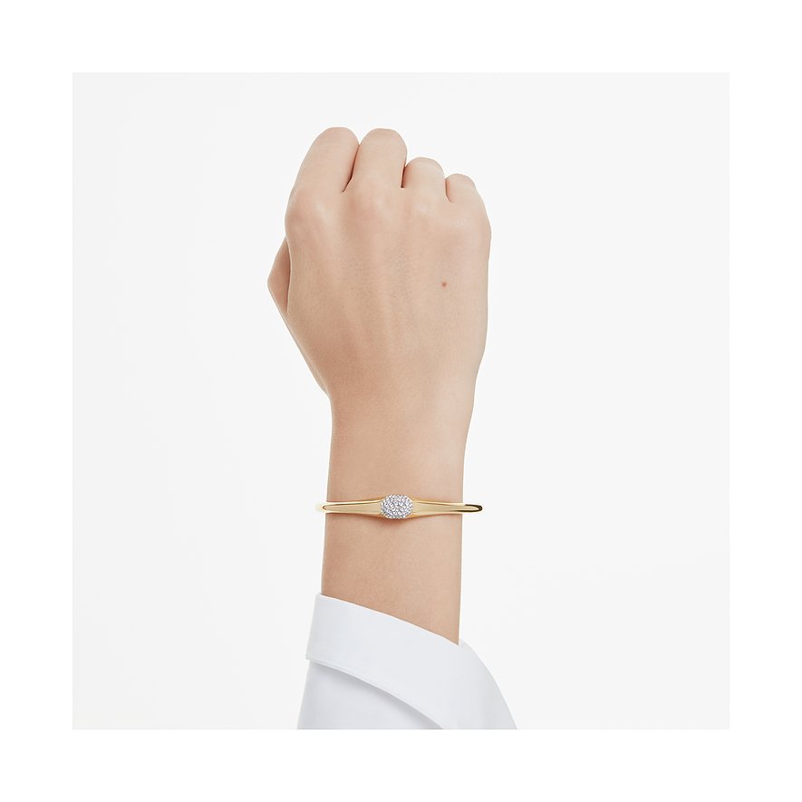Een goudkleurige Swarovski metalen armband om de pols, met een ronde gekleurde Swarovski-kristal in het midden.
