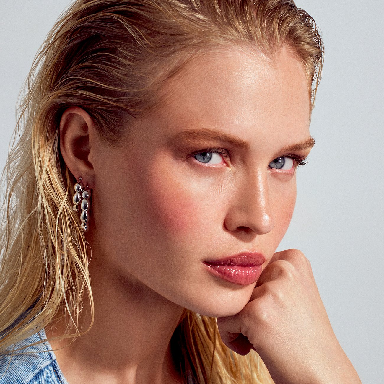 Ein model mit den Sif Jakobs Jewellery Ohrhängern aus 925er Silber mit mehreren glänzenden hängenden Elementen.