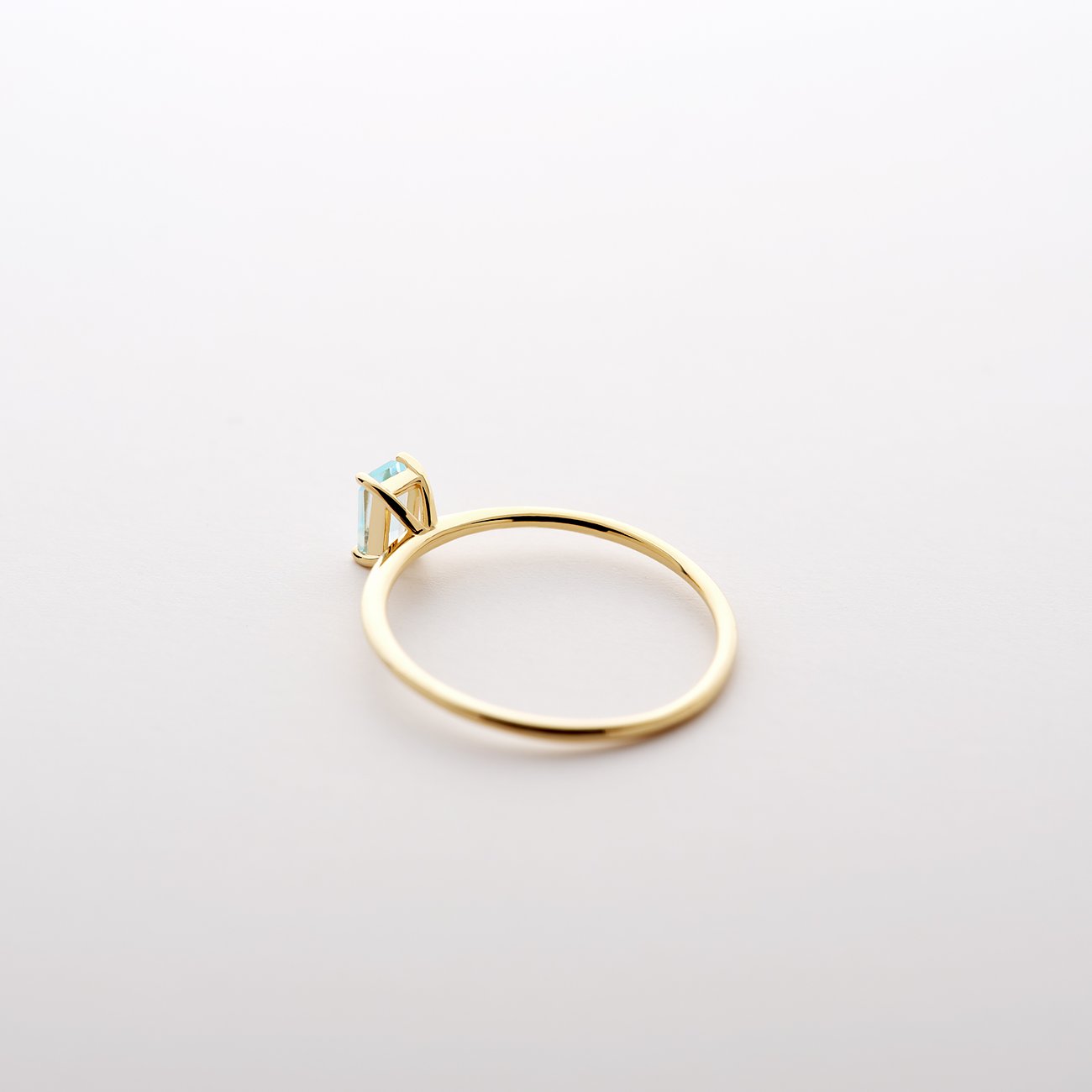 CHRIST Ring aus 585 Gelbgold mit einem hellblauen viereckigen Topas Edelstein aus der Seitenansicht.