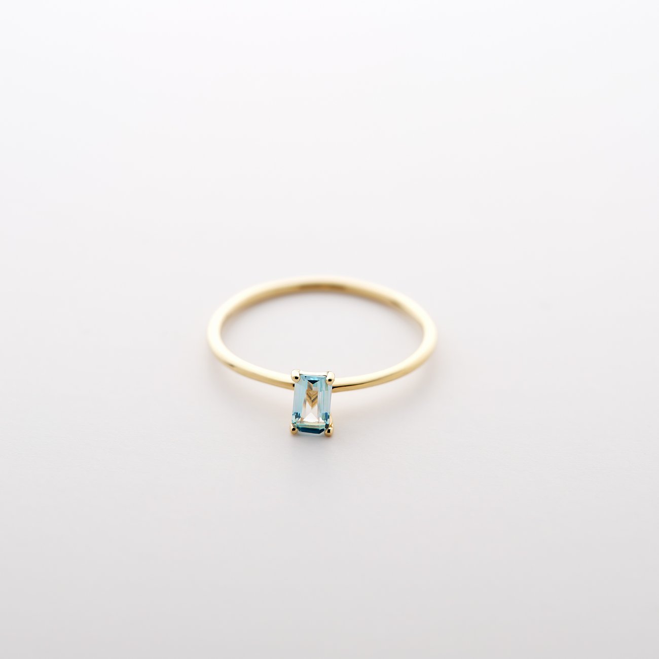 CHRIST Ring aus 585 Gelbgold mit einem rechteckigen, hellblauen Topas auf weißem Hintergrund.