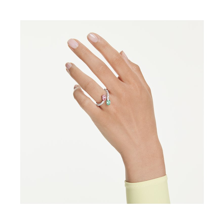 Am Ringfinger einer Hand ist ein offener Swarovski Metallring mit pinkfarbenem und grünem Swarovski-Kristall zu sehen.
