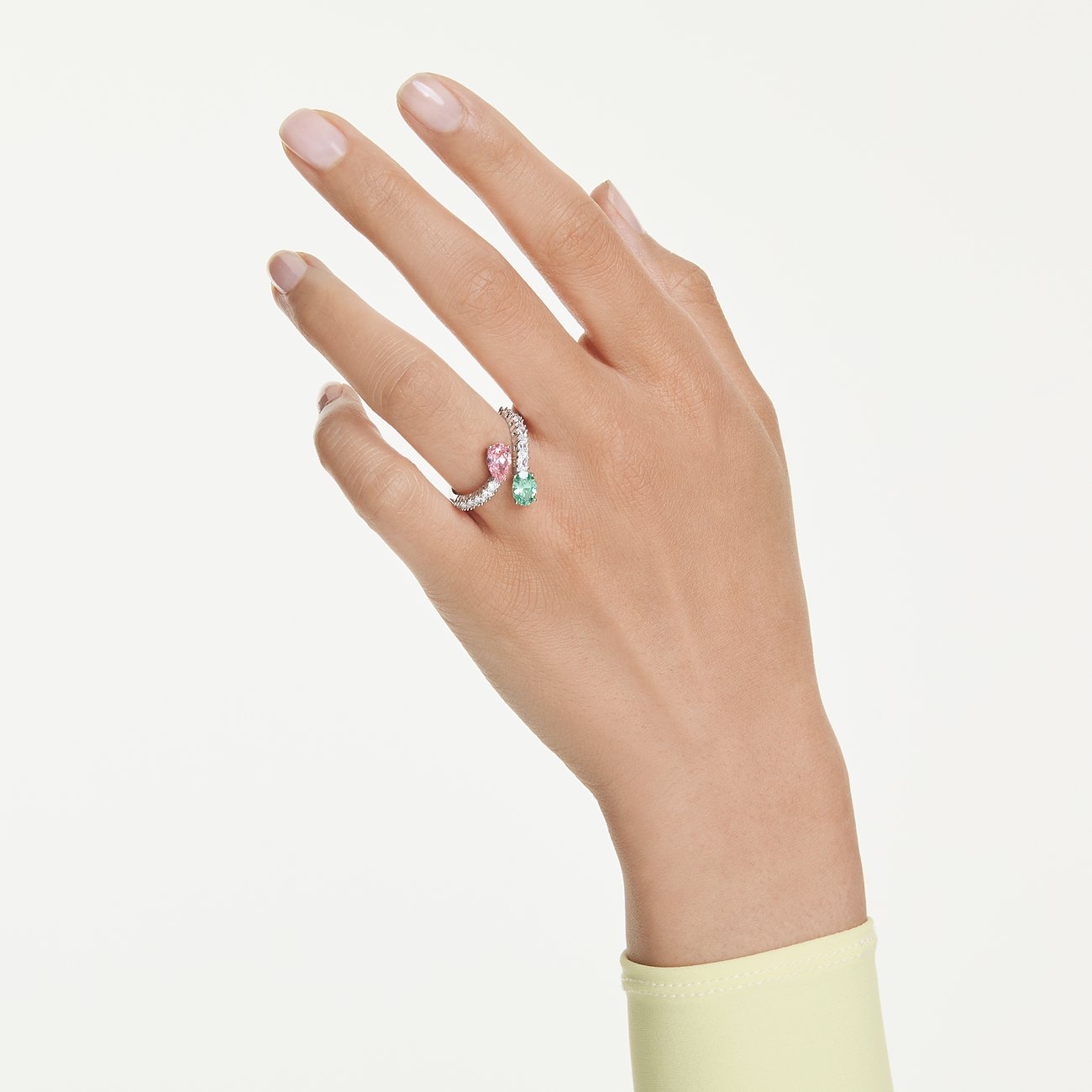 Am Ringfinger einer Hand ist ein offener Swarovski Metallring mit pinkfarbenem und grünem Swarovski-Kristall zu sehen.