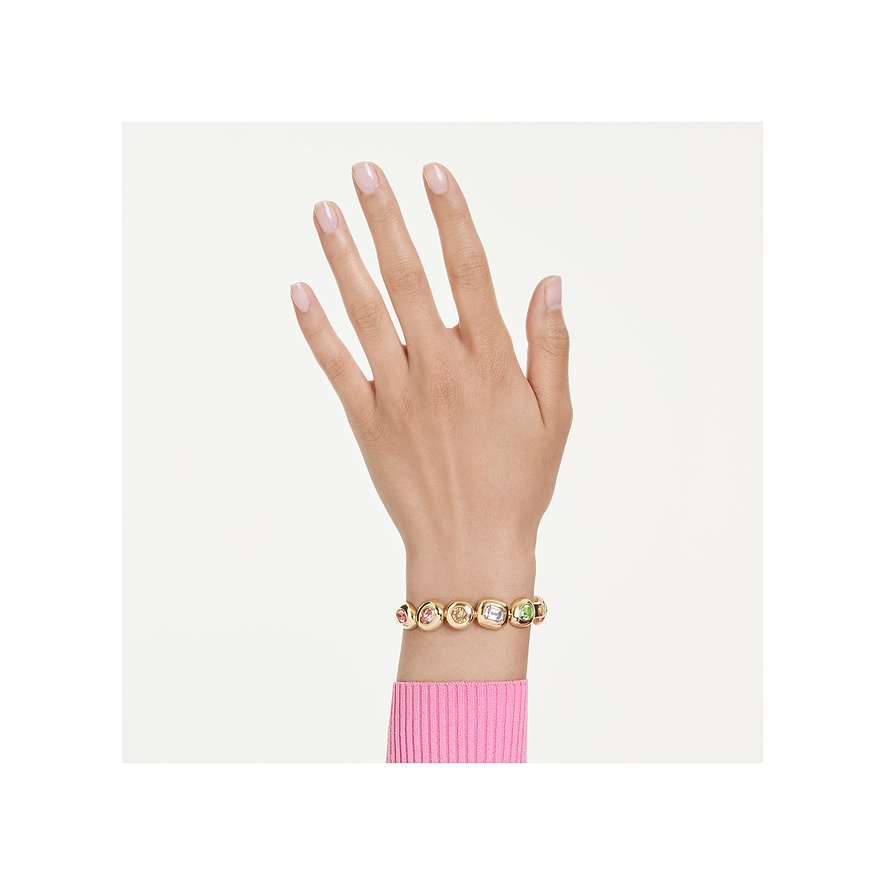 Ein Swarovski Metallarmband mit mehreren farbigen Swarovski-Kristallen in Goldtönen, getragen an einem Handgelenk.