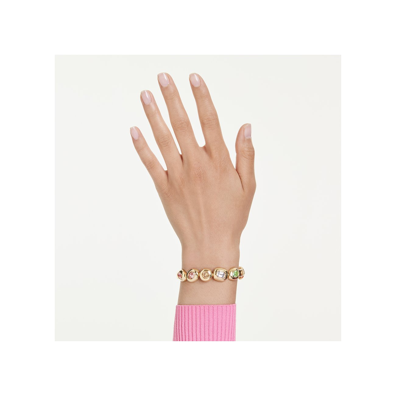 Ein Swarovski Metallarmband mit mehreren farbigen Swarovski-Kristallen in Goldtönen, getragen an einem Handgelenk.