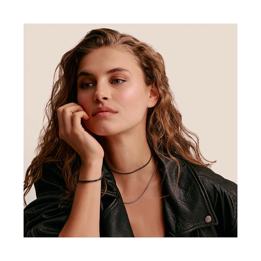 Ein Model trägt eine Thomas Sabo Halskette aus Silber mit schwarzen Zirkonia-Steinen und ein passendes Armband.