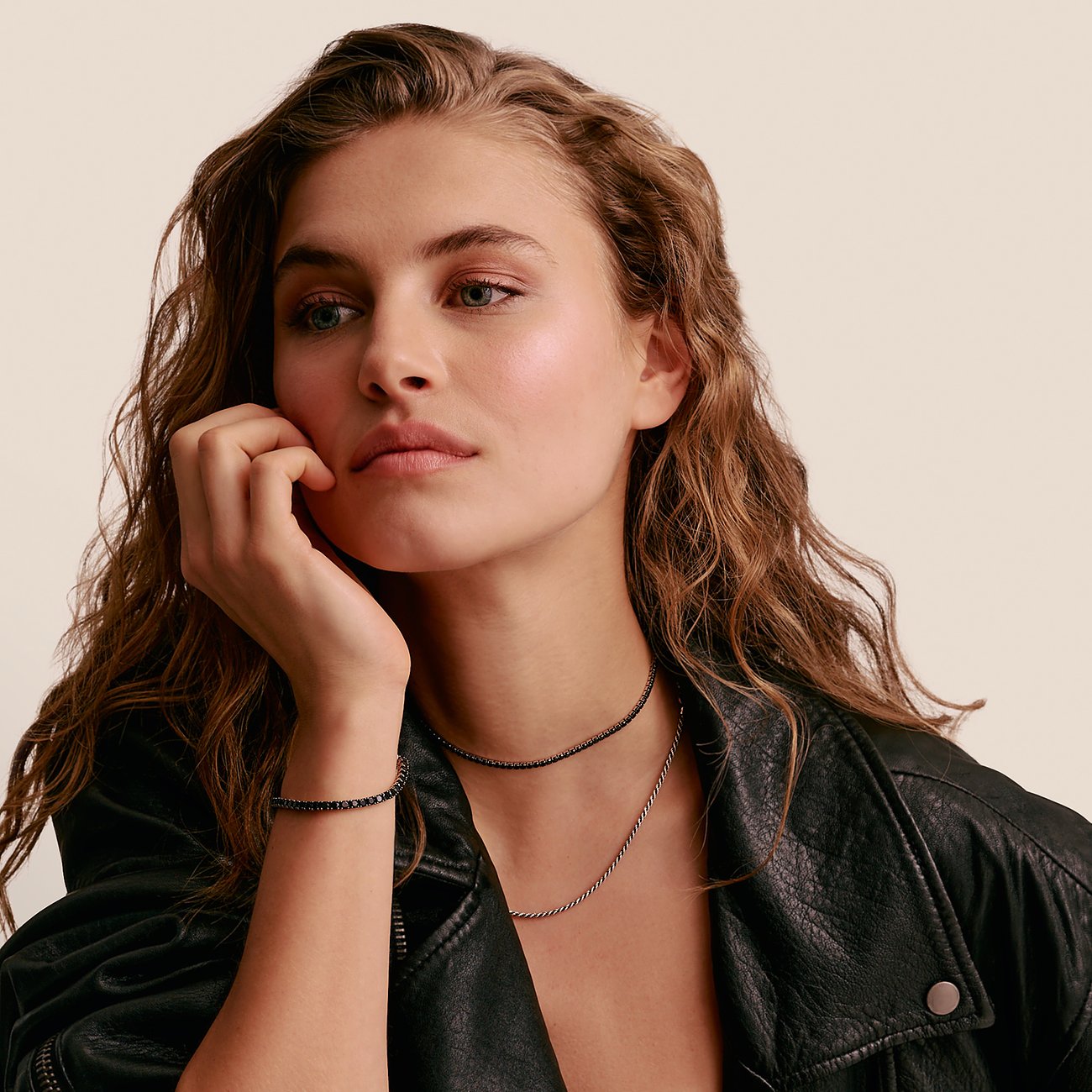 Ein Model trägt eine Thomas Sabo Halskette aus Silber mit schwarzen Zirkonia-Steinen und ein passendes Armband.