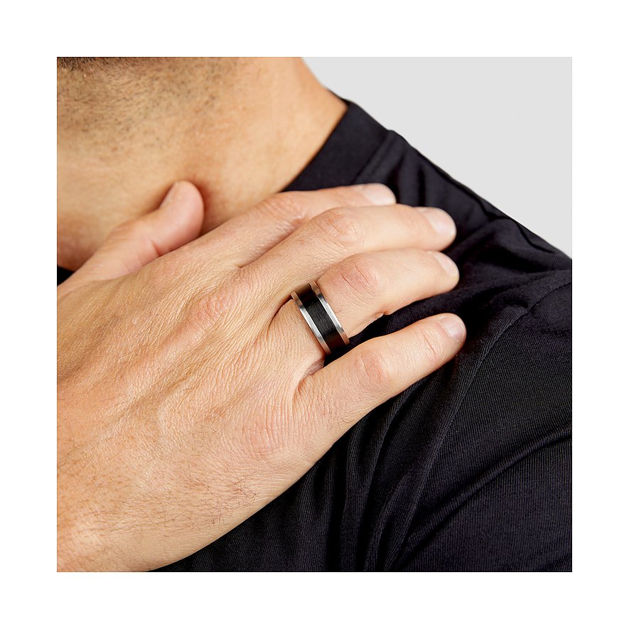 Ein s.Oliver Herrenring aus Edelstahl in Silber und Schwarz wird an einem Finger eines Mannes getragen.