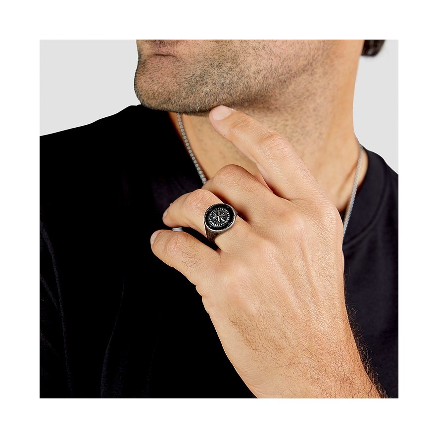 Ein Mann trägt einen s.Oliver Edelstahlring mit einem Kompassmotiv auf dem rechten Ringfinger. Nahaufnahme.