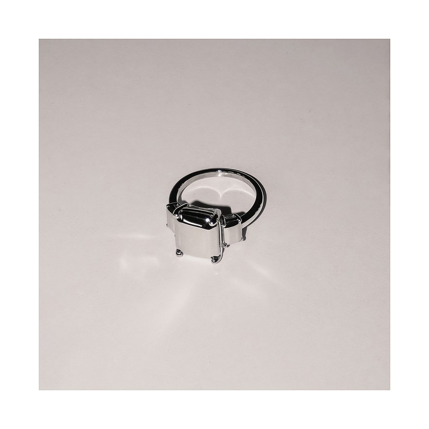 Ein glänzender Liebeskind Ring aus Edelstahl mit rechteckigem Design, von oben fotografiert.