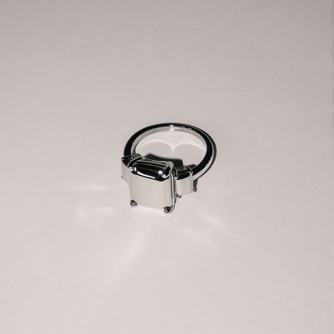 Ein glänzender Liebeskind Ring aus Edelstahl mit rechteckigem Design, von oben fotografiert.