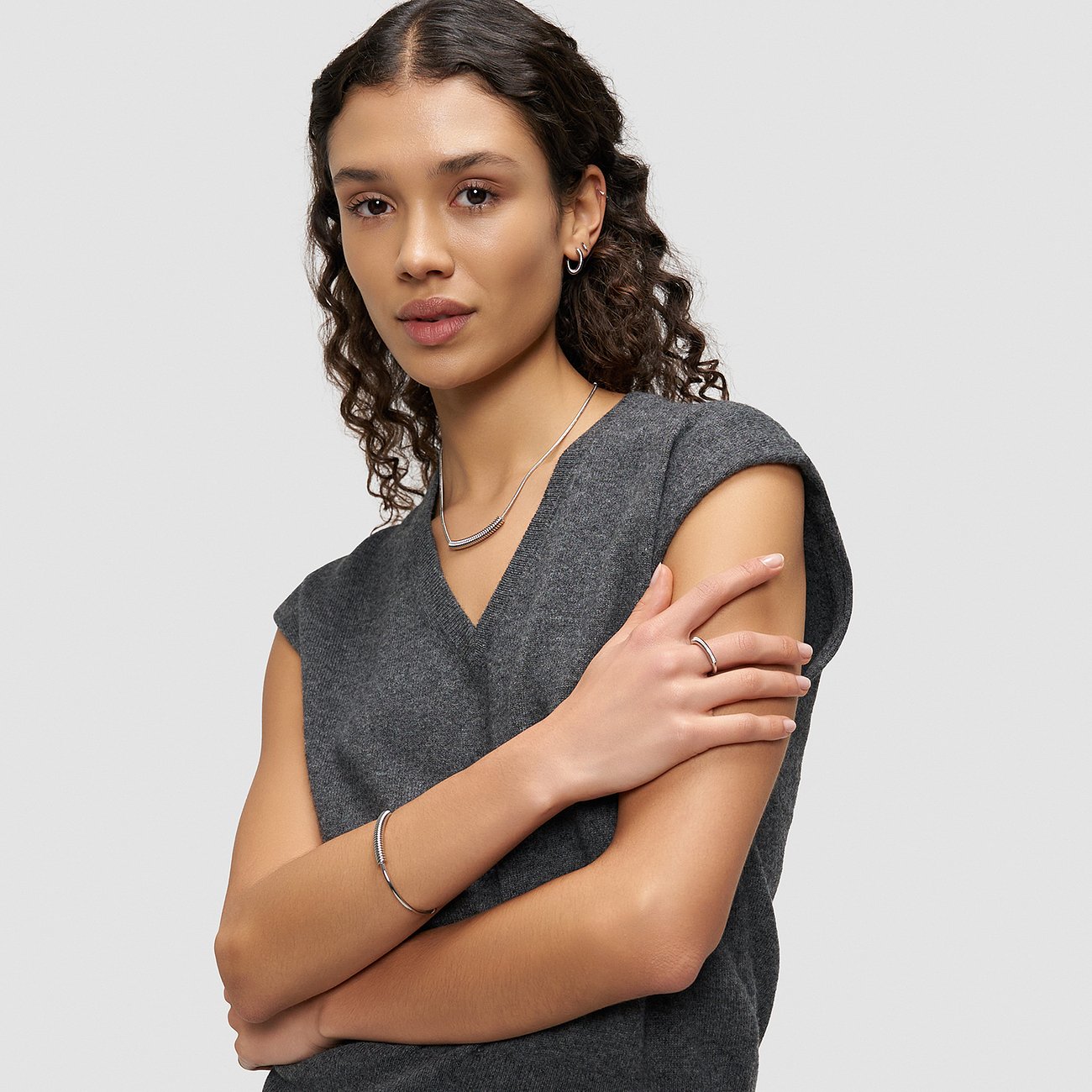 Modellen bär en Liebeskind ring, halsband, armringar och örhängen i rostfritt stål på höger hand.
