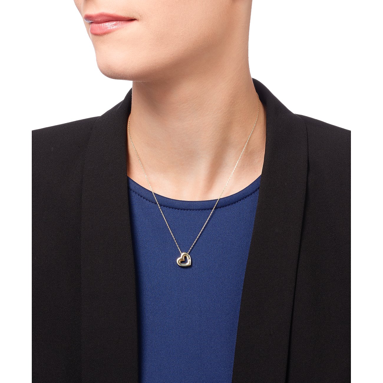 CHRIST Herzkette aus Gelbgold mit funkelnden Diamanten sitzt elegant auf der Brust einer Frau. Klassischer Halsschmuck.