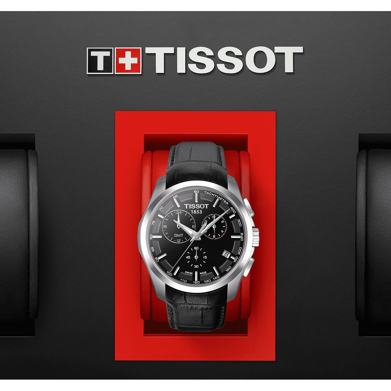 Eine Tissot Herrenuhr aus Edelstahl mit schwarzem Zifferblatt und Lederarmband liegt in einer roten Schatulle.