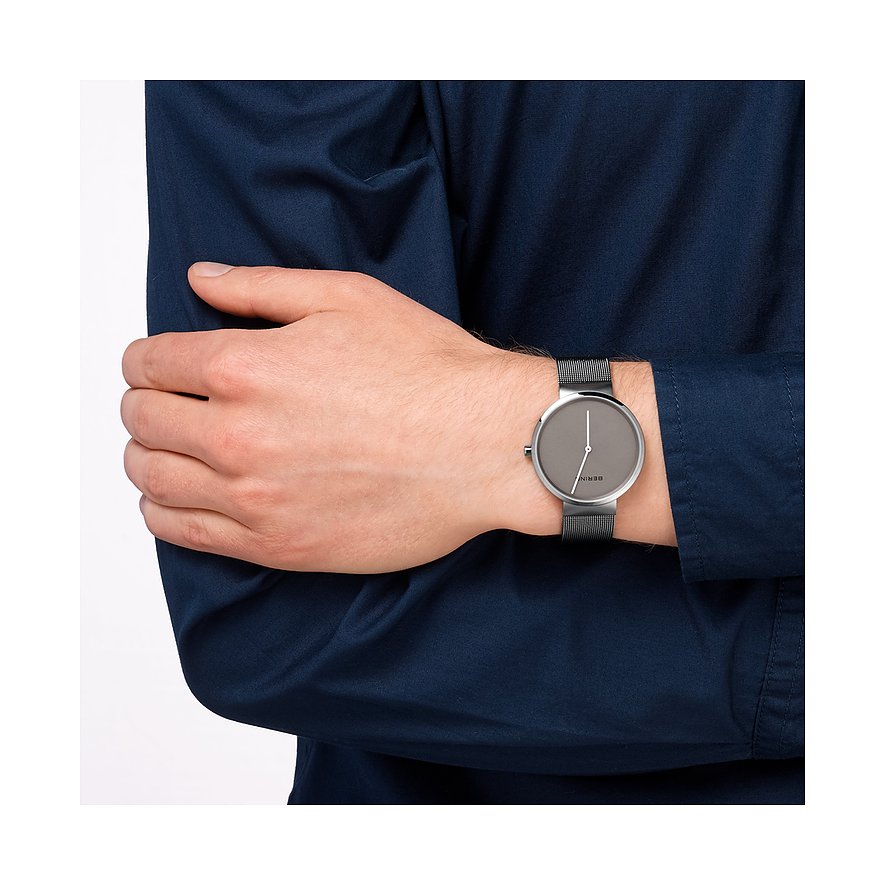Am Handgelenk eines Mannes getragene Armbanduhr von Bering aus silberfarbenem Edelstahl mit grauem Zifferblatt.