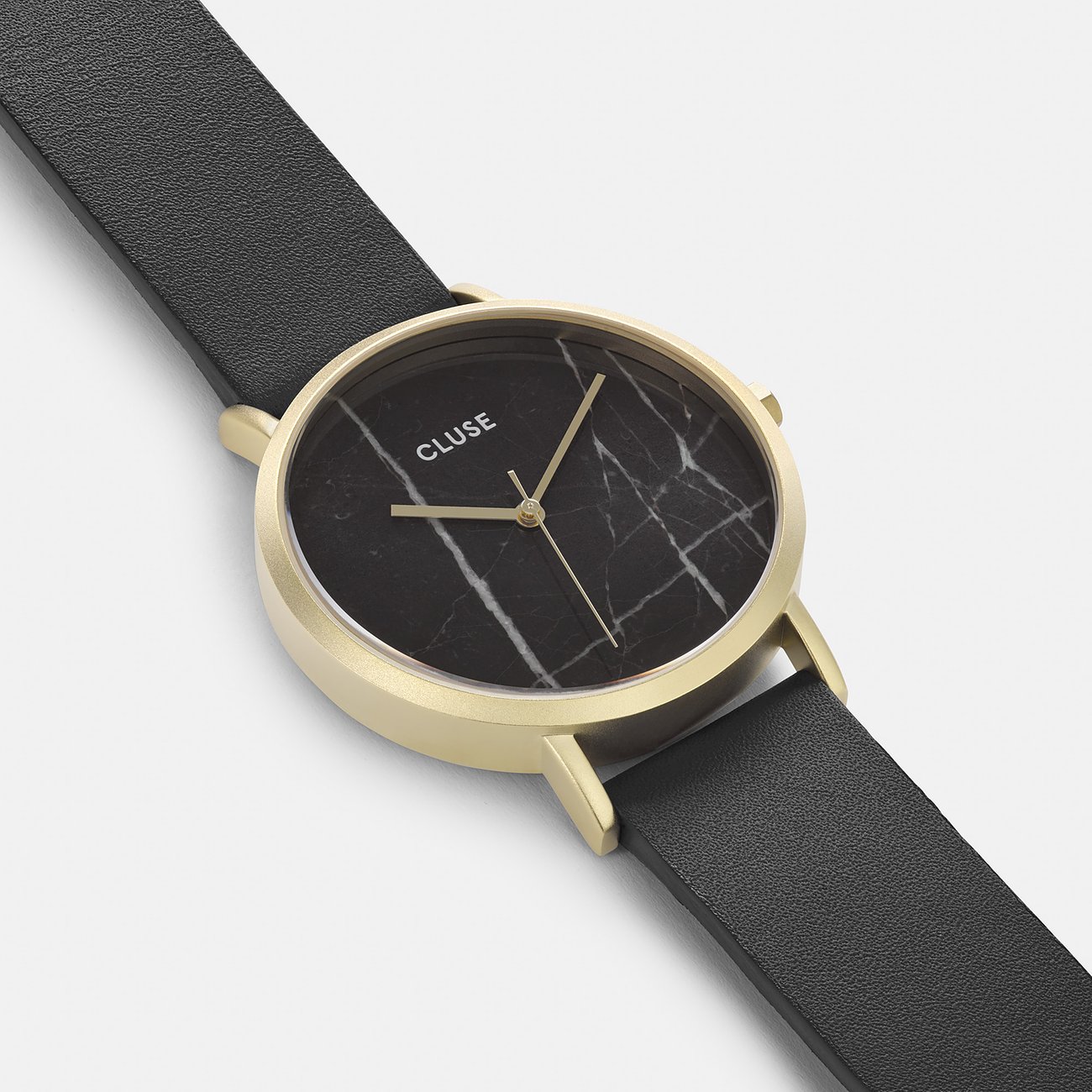Nahaufnahme einer Cluse Damenuhr mit schwarzem Lederarmband und einem Zifferblatt aus schwarzem Marmor mit Goldgehäuse.