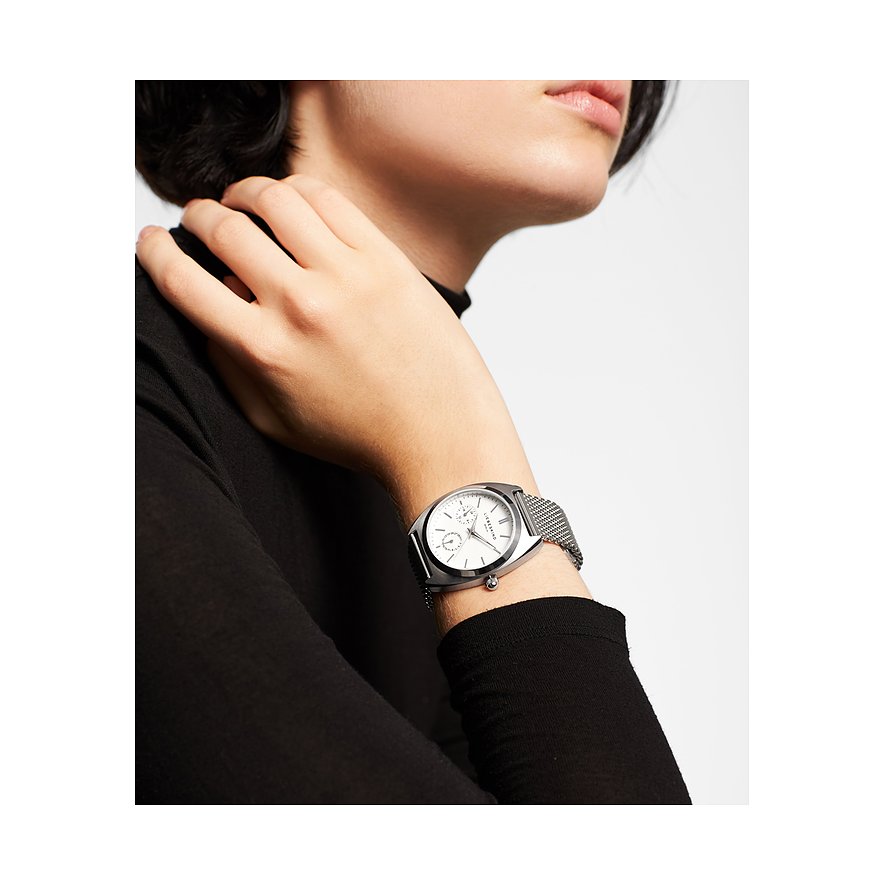 Nahaufnahme einer Liebeskind Damenuhr aus Edelstahl mit silbernem Mesh-Armband und weißem Zifferblatt am Handgelenk.