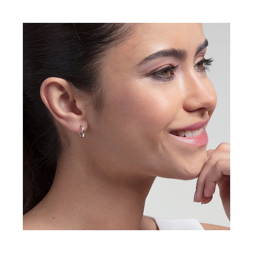 Close-up van glimlachende vrouw met één ronde Thomas Sabo 925 zilveren oorbel aan haar linkeroor.