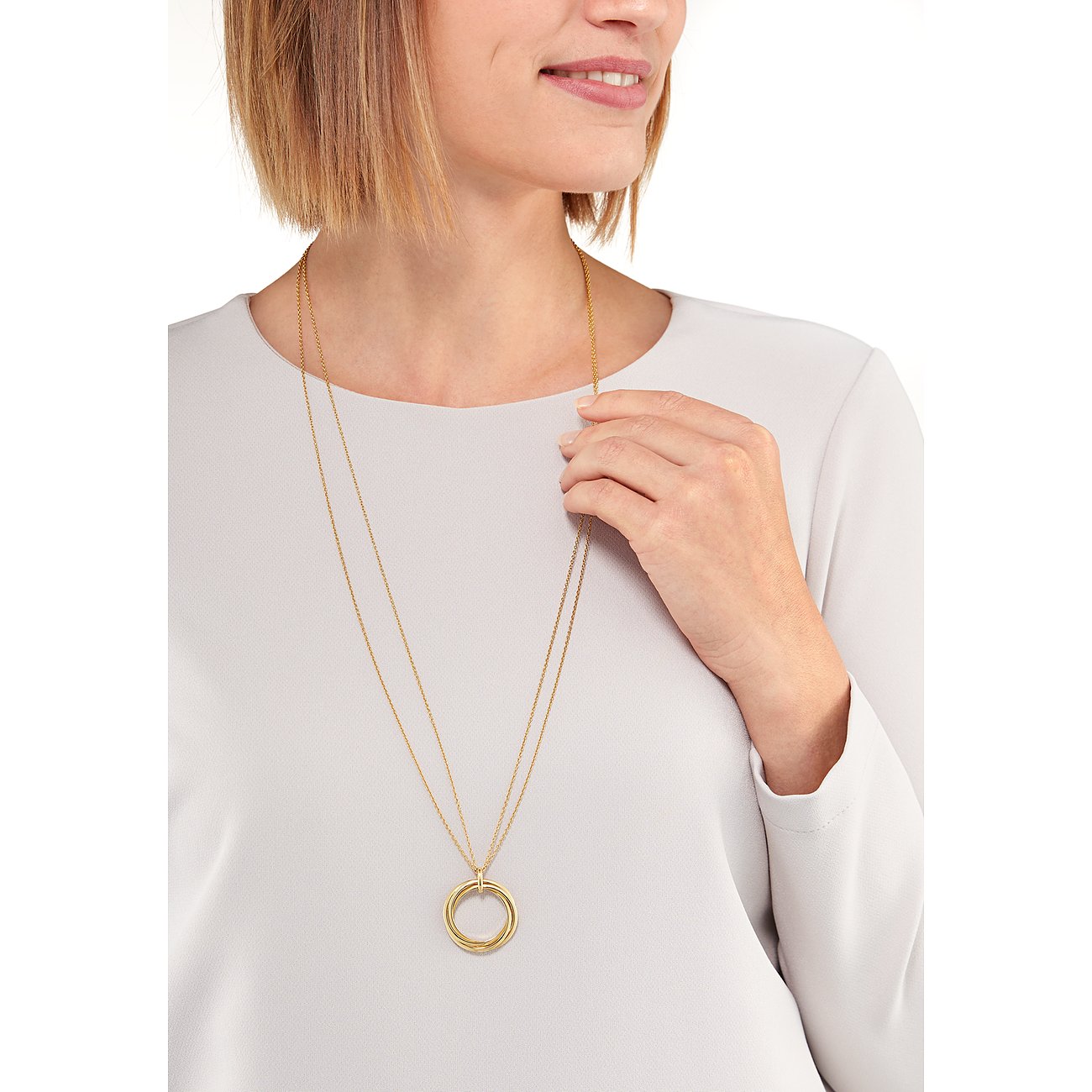 Ein Model trägt einen langen CHRIST Halsschmuck aus Gelbgold 585 mit ineinander verschlungenen Ringen als Anhänger.