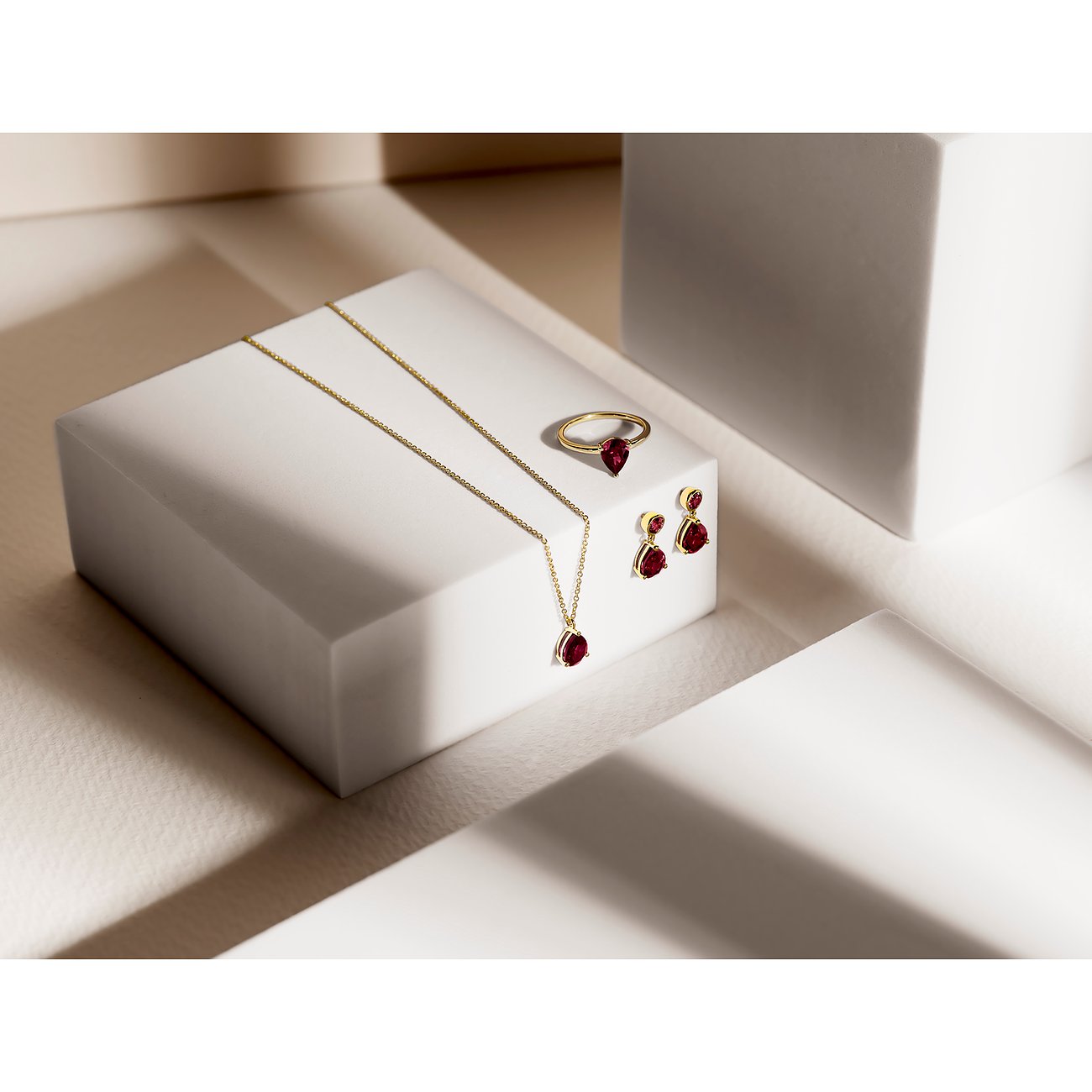 CHRIST Ohrschmuck Set aus Gelbgold: Halskette, Ring und Ohrringe mit tropfenförmigen Rhodolith Schmucksteinen.