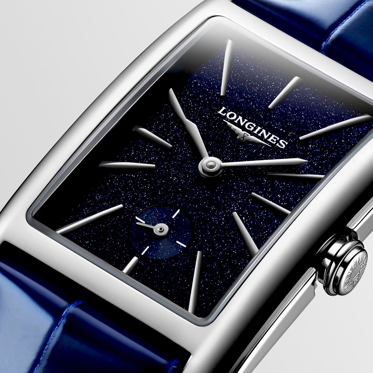 Nahaufnahme einer rechteckigen Longines Damenuhr aus Edelstahl mit glitzerndem blauem Zifferblatt und blauer Lederband.