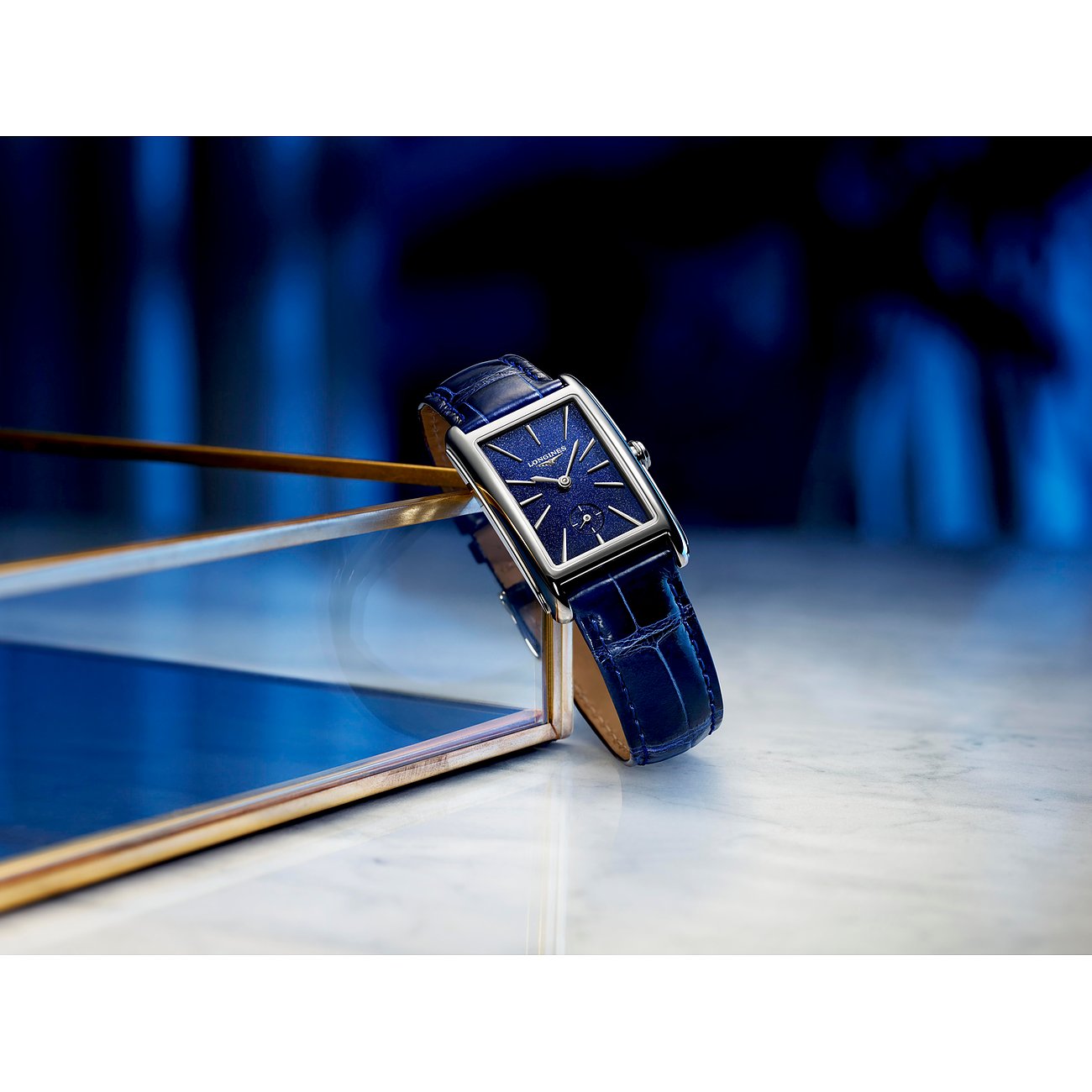Nahaufnahme einer Longines Damenuhr aus Edelstahl mit rechteckigem Zifferblatt und blauem Lederarmband, schräg von oben.