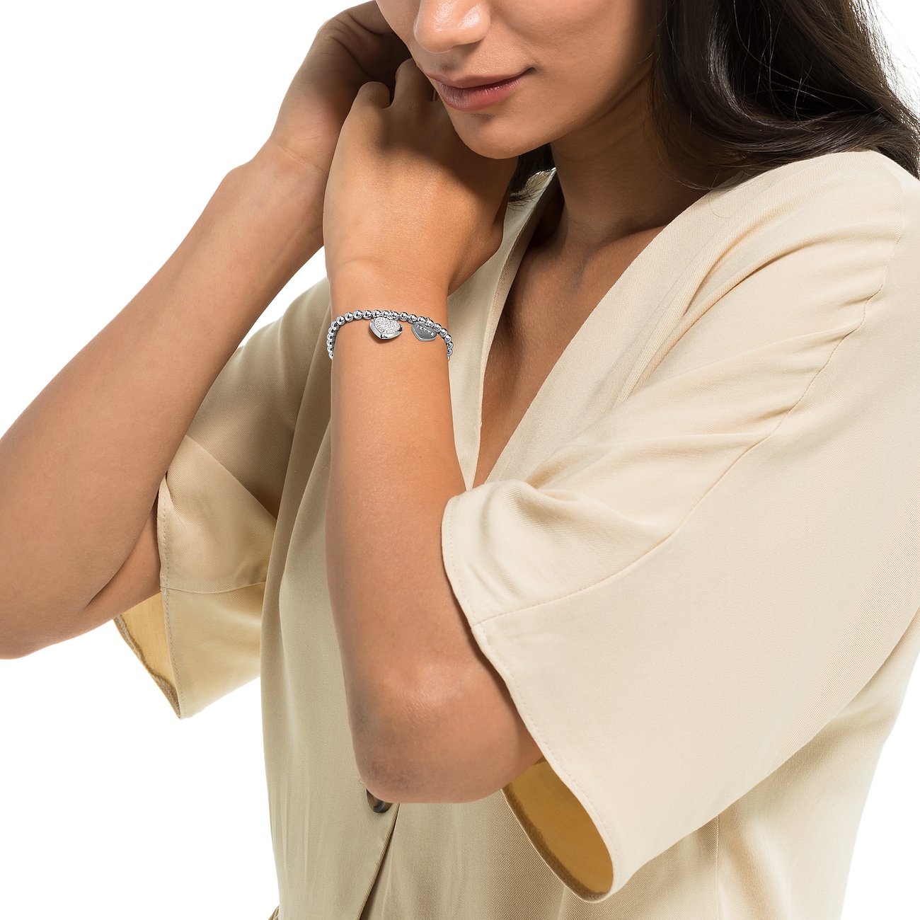 Frau trägt ein JETTE Silberarmband mit Zirkonia und zwei Anhängern, bestehend aus kleinen Silberkugeln.