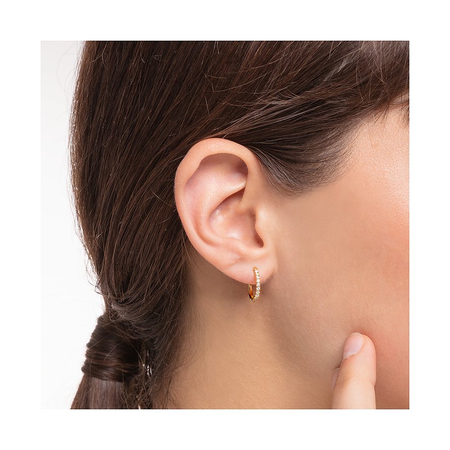 Ein glänzender Thomas Sabo Ohrschmuck aus 925er Silber mit Zirkonia, getragen von einem Model.
