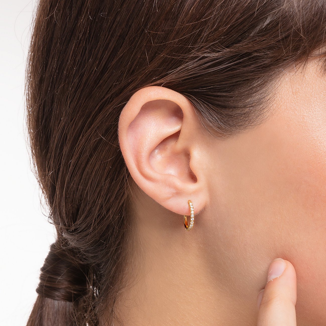 Ein glänzender Thomas Sabo Ohrschmuck aus 925er Silber mit Zirkonia, getragen von einem Model.