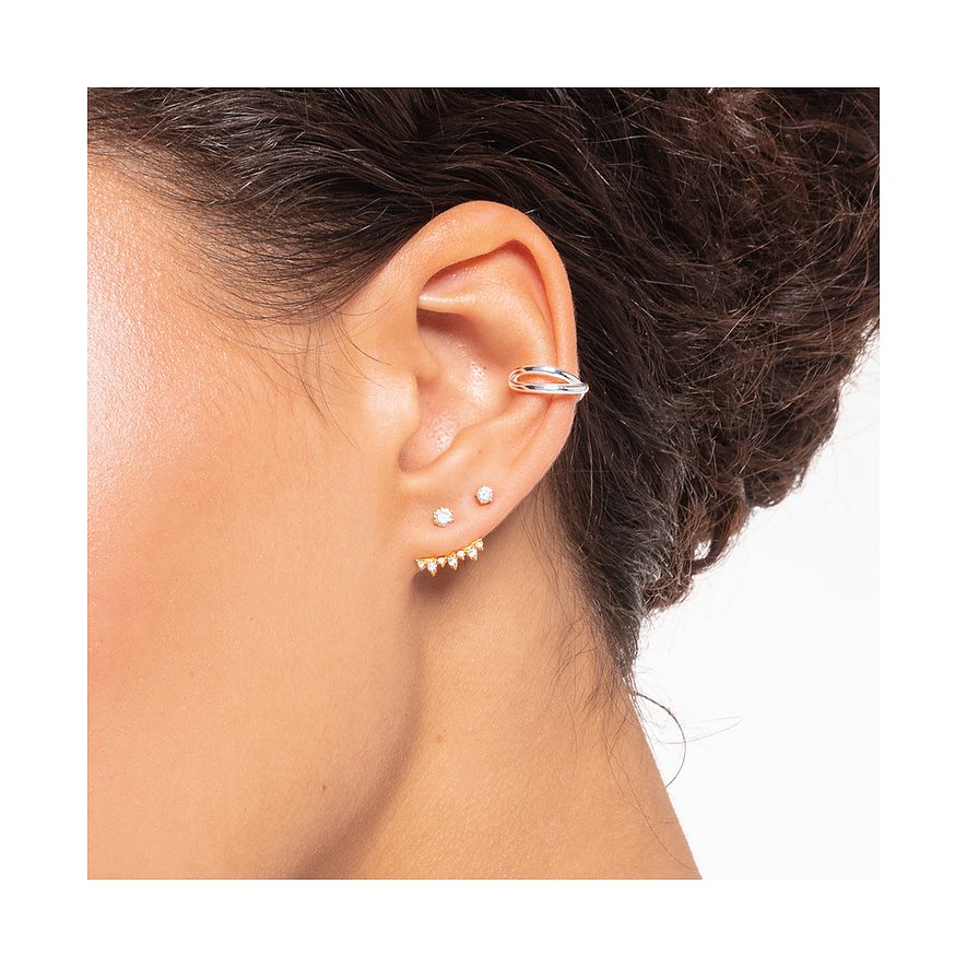 Nahaufnahme einer weiblichen Ohrpartie mit Thomas Sabo Silberschmuck. Mehrere Ohrringe mit Zirkonia-Farbsteinen.