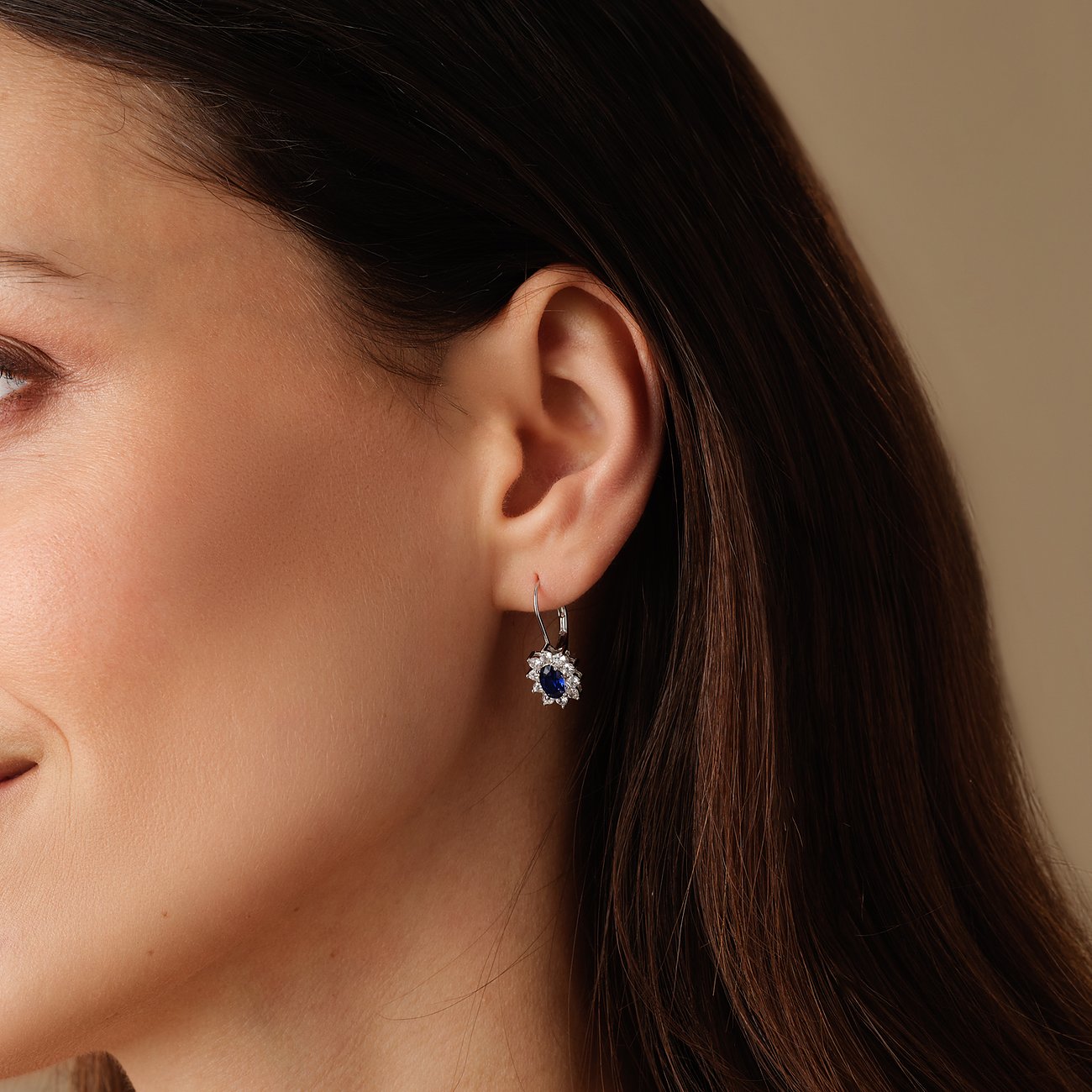 FAVS ørering i 925 sølv, en enkelt hængeørering på en kvindes øre, med en blå zirkonia ædelsten.