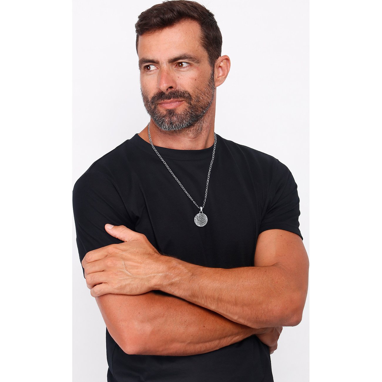 Kuzzoi Halsschmuck: Silberkette mit rundem, graviertem Anhänger, der von einem Mann getragen wird.