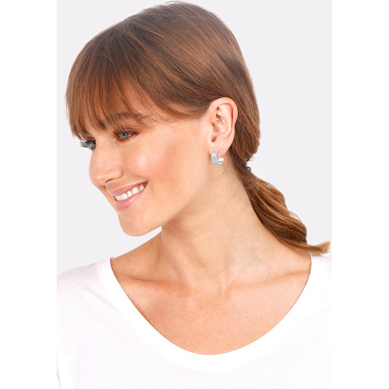 Ein Model trägt einen einzelnen Elli 925 Silber Ohrschmuck Creolen mit gerilltem Design am Ohr.