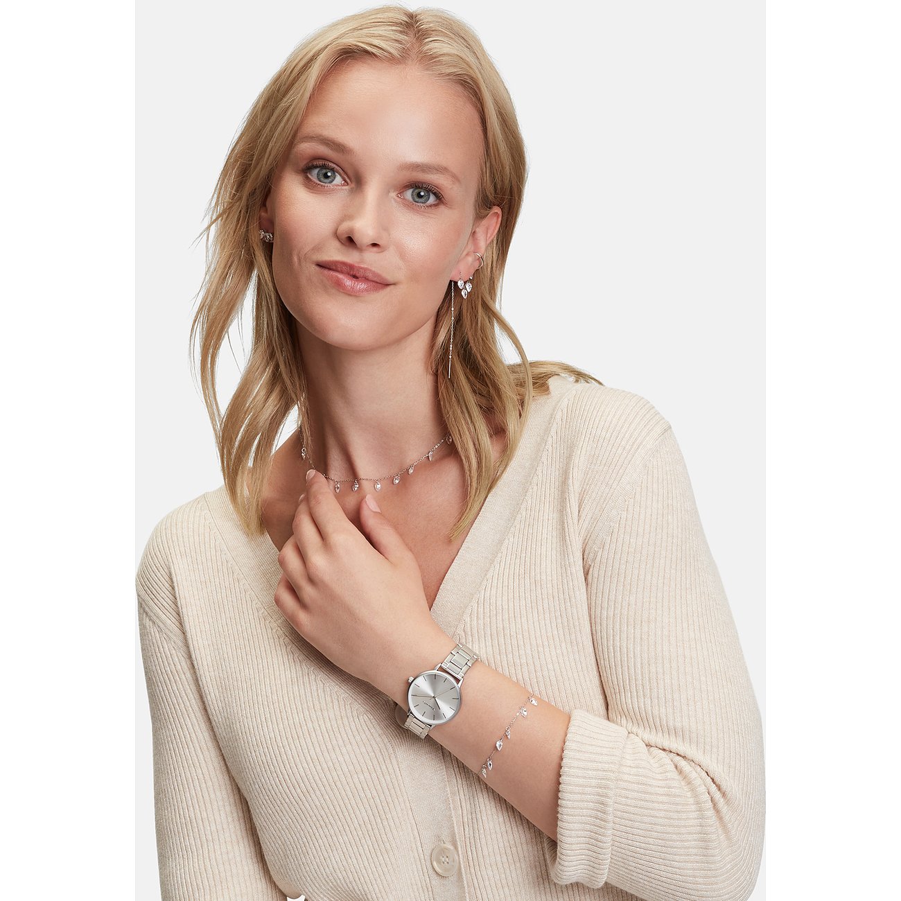 Lachende Frau mit Tamaris Edelstahlkette mit Zirkonia-Farbsteinen und Armbanduhr.