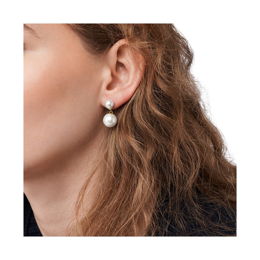Skagen örhänge i rostfritt stål med två hängande pärlor buret på ett öra, närbild.