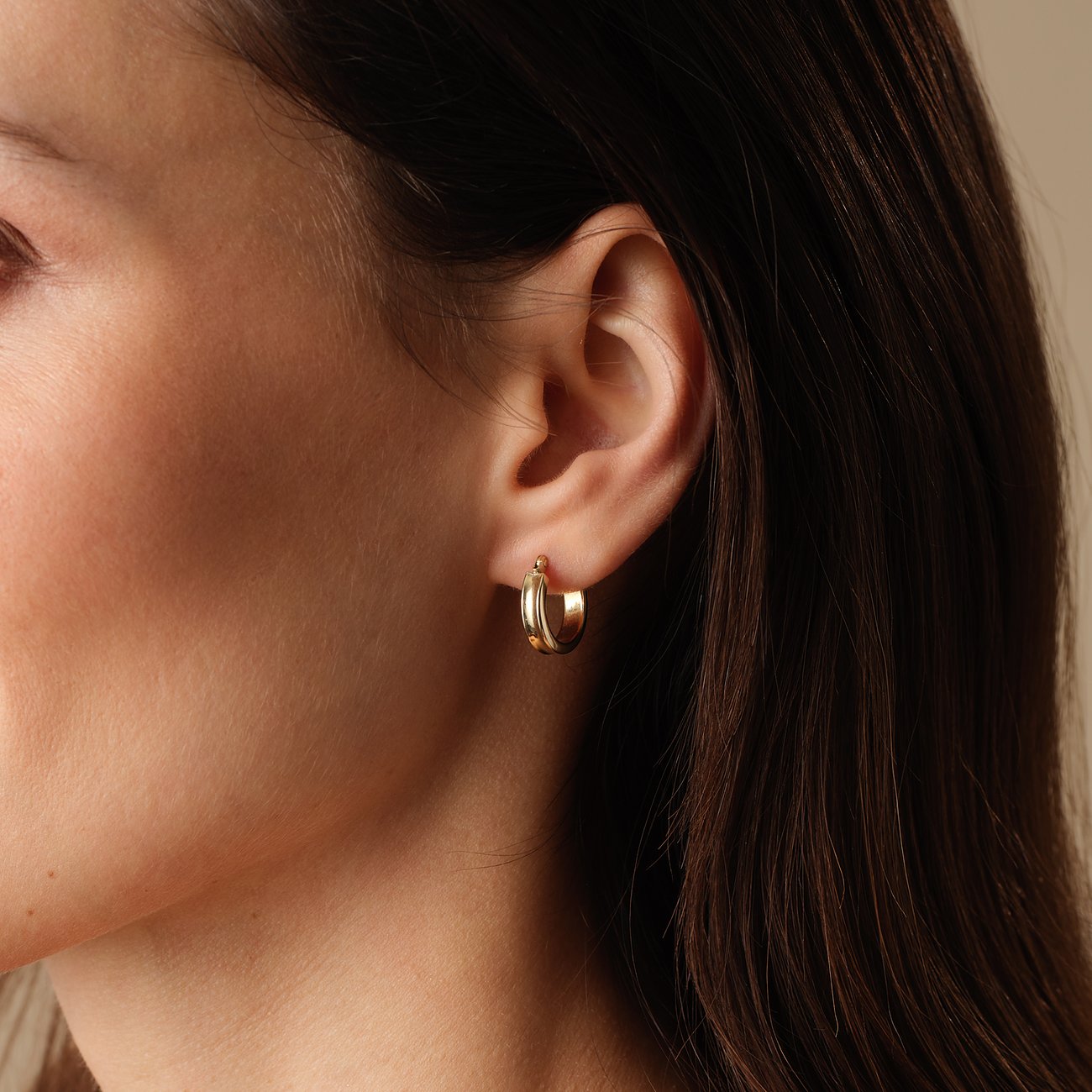 FAVS gouden creolen van geelgoud aan één oor gedragen, zichtbaar van opzij.