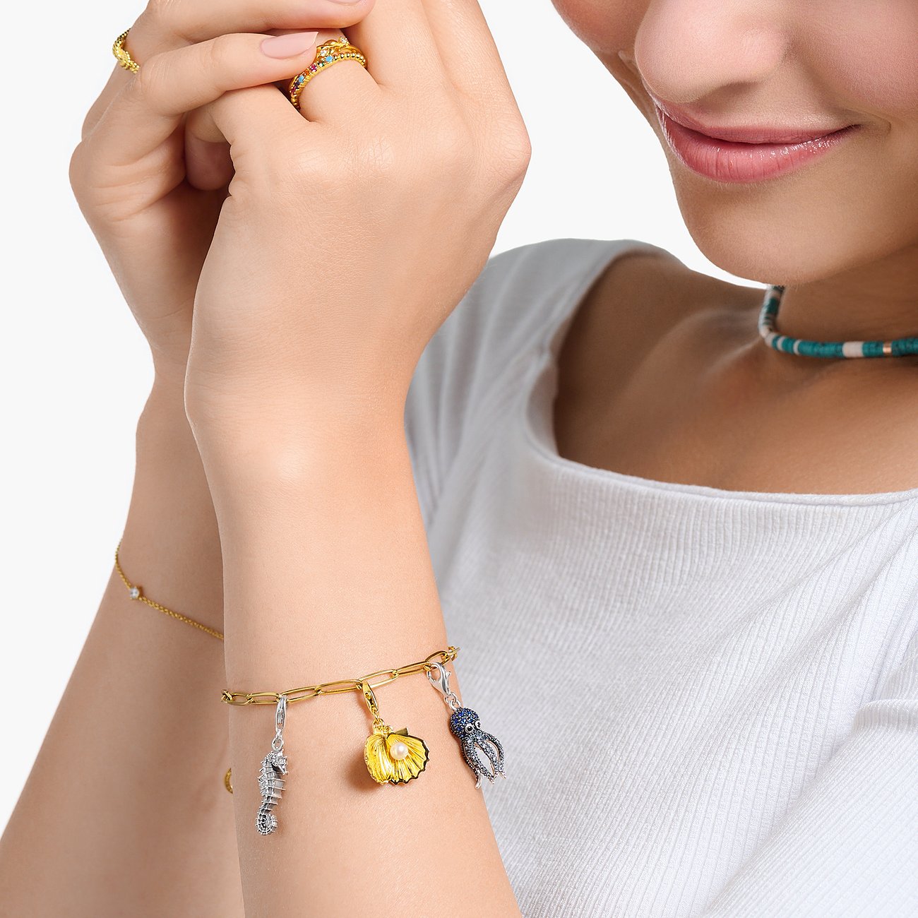 Closeup: Kvinde bærer Thomas Sabo armbånd med søhest-, musling- & blæksprutte-vedhæng af 925 sterlingsølv m. zirkonia.