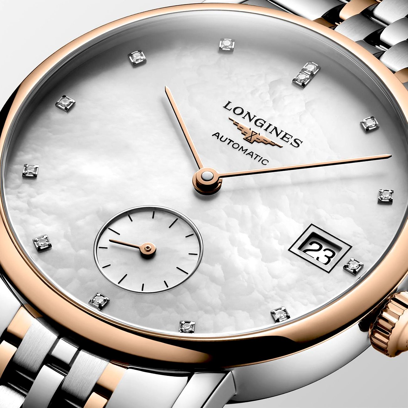 Nahaufnahme einer Longines Damenuhr aus Edelstahl und Roségold mit Diamanten auf dem Perlmuttzifferblatt.