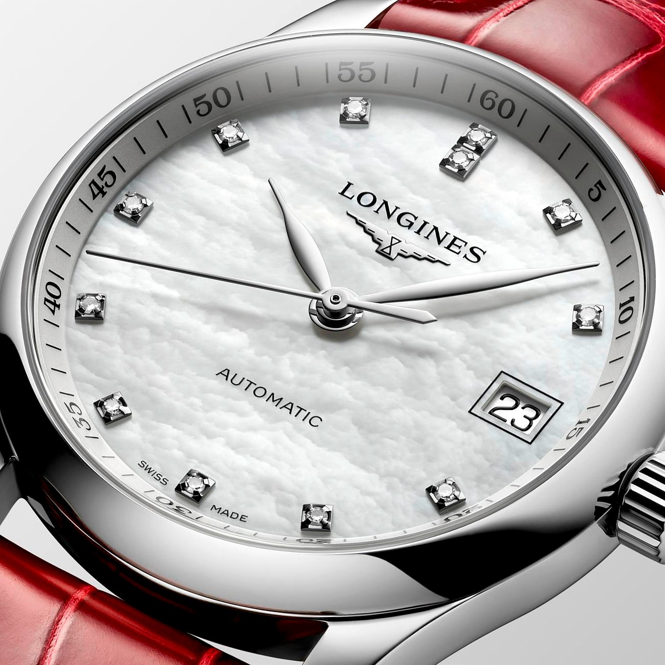 Nahaufnahme der Longines Damenuhr aus Edelstahl mit Diamanten auf einem perlmuttfarbenen Zifferblatt, rotem Armband.