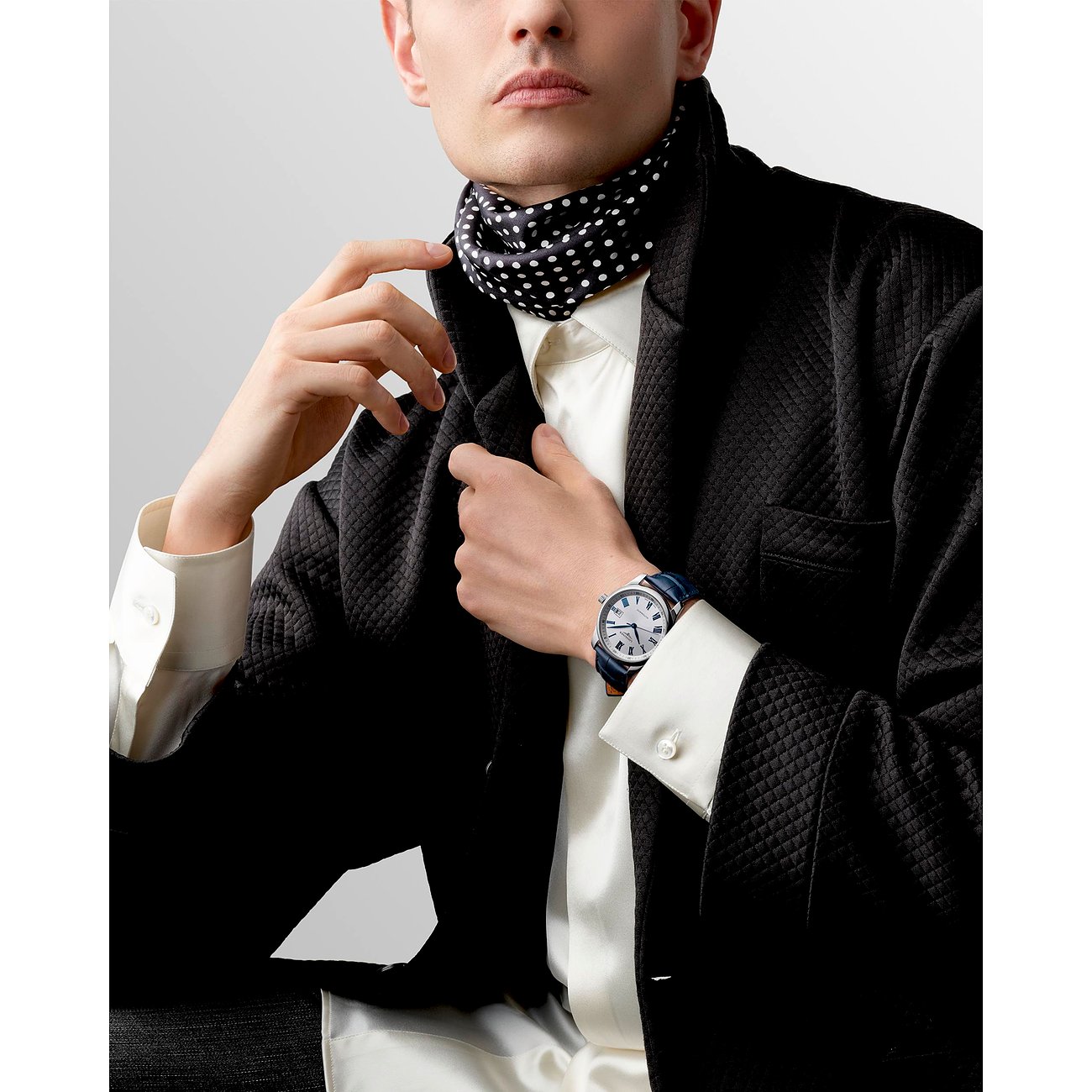 Am Handgelenk eines Mannes wird eine runde Longines Herrenuhr aus blauem Edelstahl mit Lederband präsentiert.