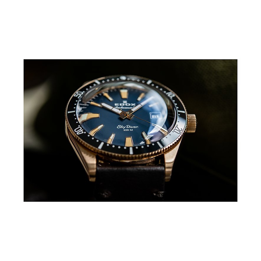 Die Edox SkyDiver Automatikuhr aus Edelstahl mit einem blauen Zifferblatt und goldenen Akzenten ist schräg von oben zu sehen.