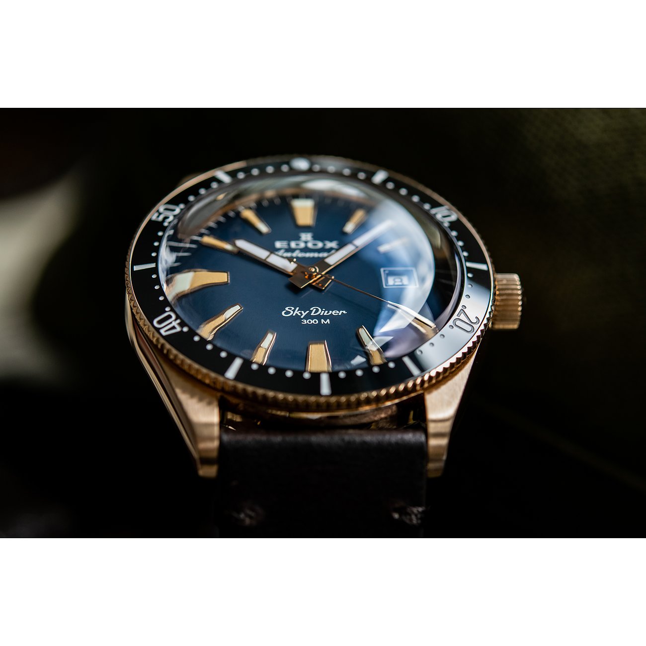 Die Edox SkyDiver Automatikuhr aus Edelstahl mit einem blauen Zifferblatt und goldenen Akzenten ist schräg von oben zu sehen.