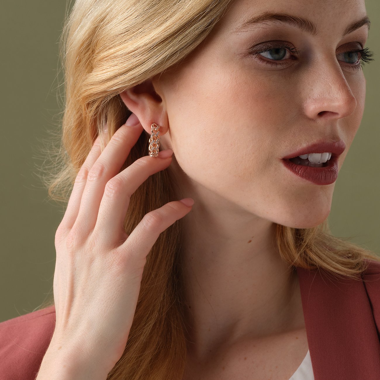 Närbild av modell som bär en JETTE örhänge i roséguldfärgat silver med zirkonia och kedjelänkar.