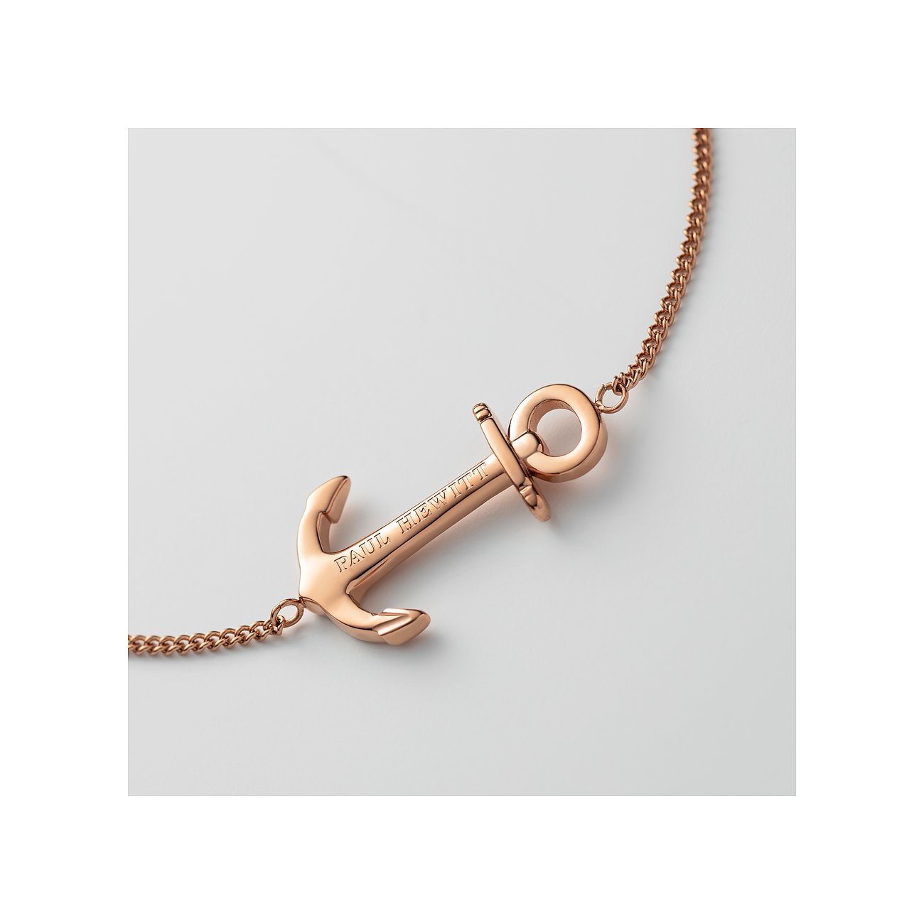 Primo piano di un bracciale Paul Hewitt color oro rosa in acciaio inossidabile riciclato con dettaglio ancora.
