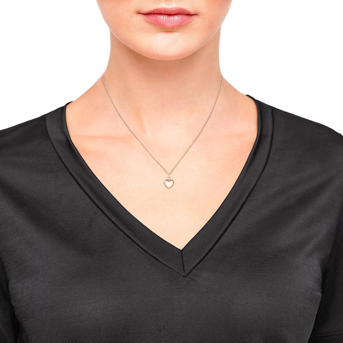 Una donna indossa una catena d'argento s.Oliver con un pendente a cuore, impreziosito da scintillanti zirconi.