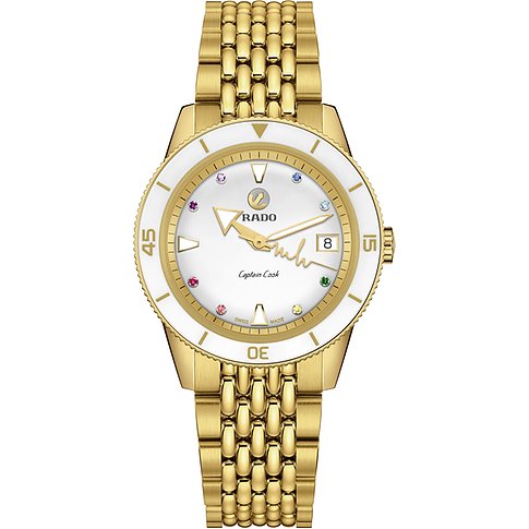Eine goldene Rado Captain Cook Uhr aus Edelstahl mit weißem Zifferblatt und bunten Farbsteinen auf vier Positionen.