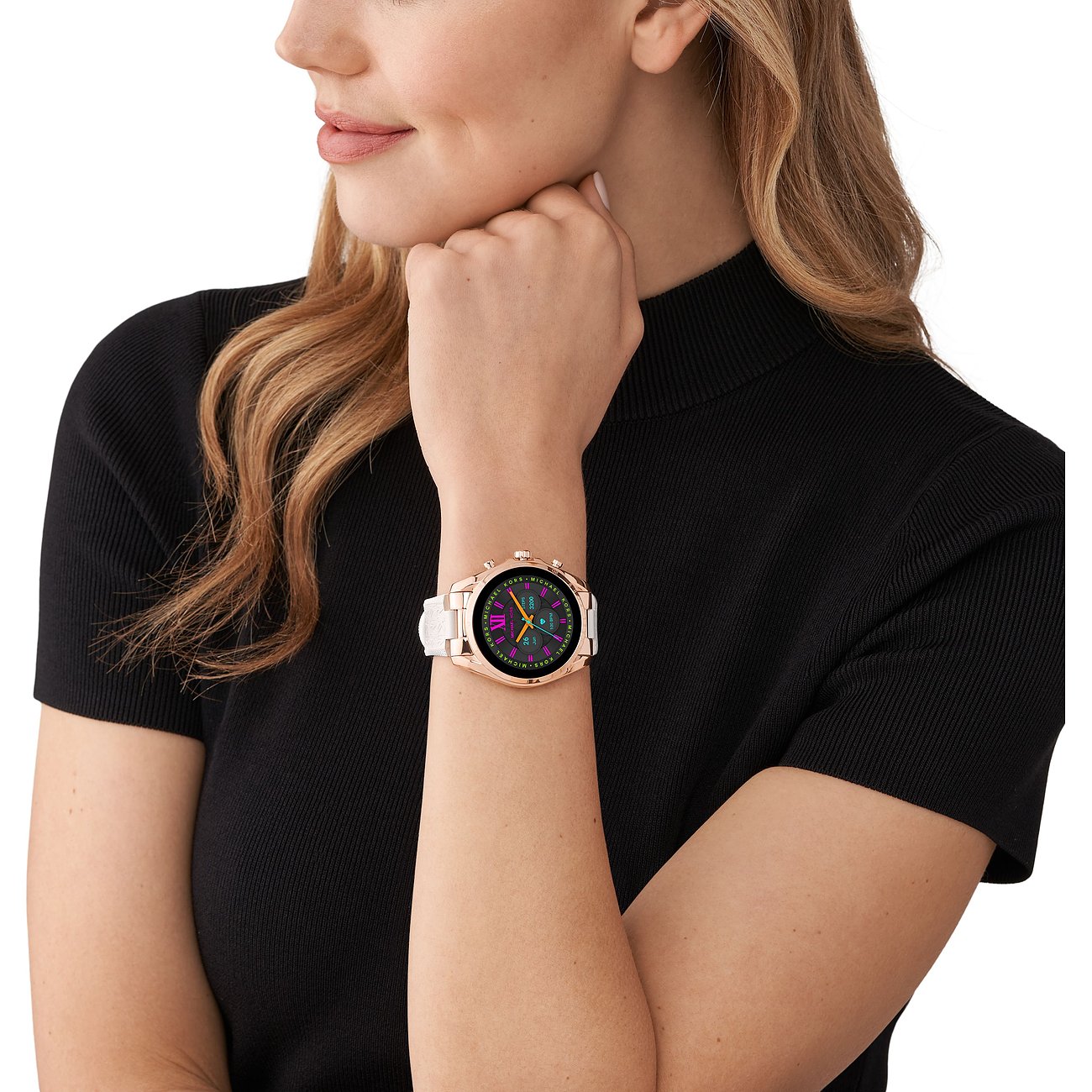 En roséguldfärgad Michael Kors smartklocka i rostfritt stål sitter på en kvinnas handled.