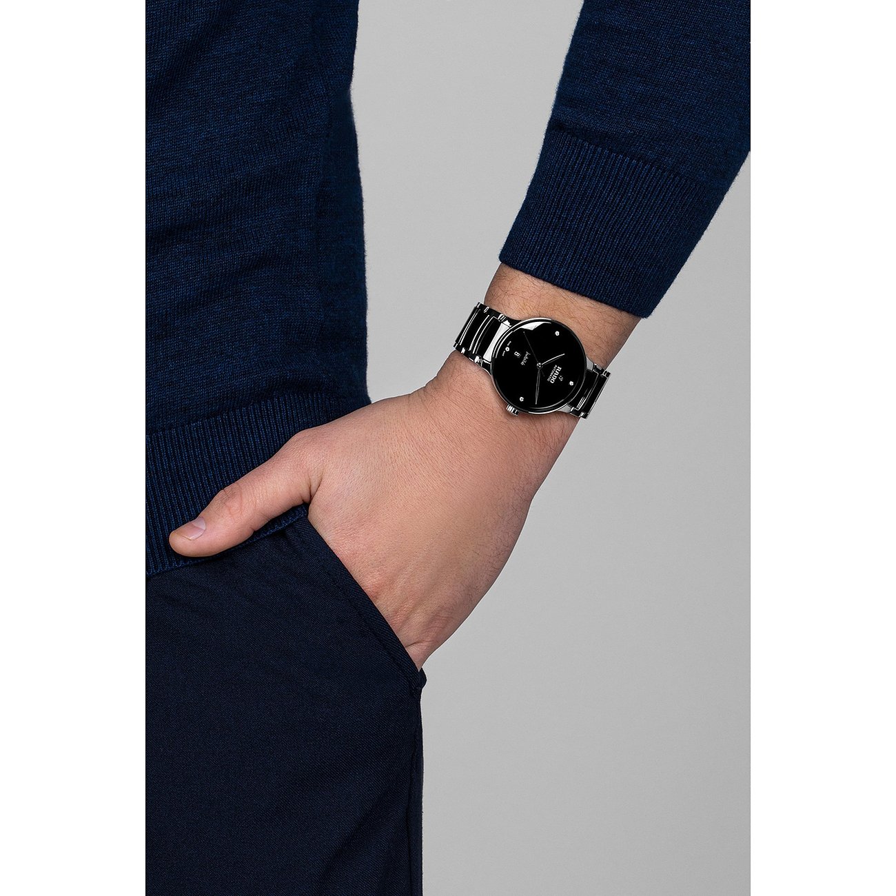 Nahaufnahme einer Rado Unisex-Uhr aus Edelstahl mit Diamanten und schwarzem Zifferblatt, am Handgelenk getragen.