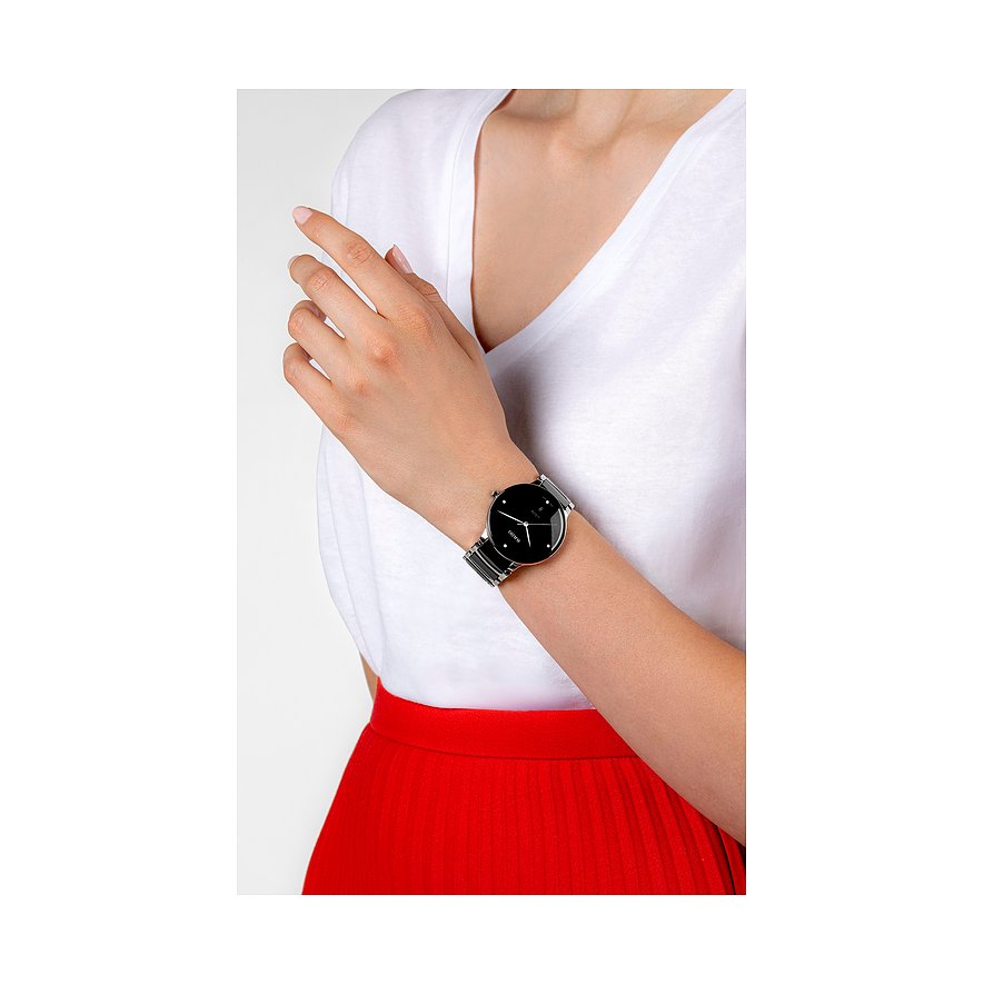 Nahaufnahme einer Rado Unisexuhr aus Edelstahl mit Diamanten und schwarzem Zifferblatt am Handgelenk.