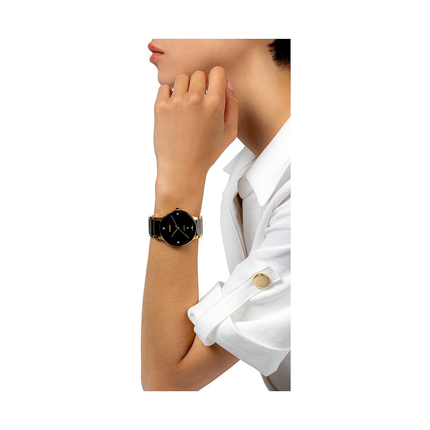 Nahaufnahme einer Rado Unisex-Uhr aus Edelstahl, getragen an einem Handgelenk, mit schwarzem Zifferblatt und Diamant.
